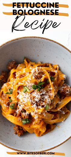 a white bowl filled with pasta covered in meat and cheese on top of a wooden table