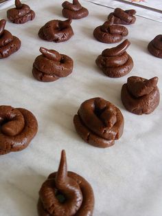 chocolate doughnuts are lined up on a baking sheet