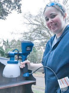 a woman is holding a paint sprayer