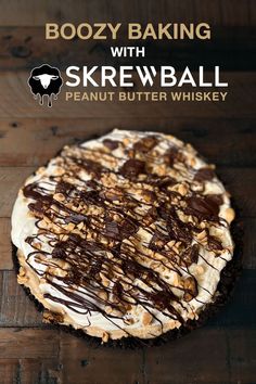 a chocolate and peanut butter cheesecake on a wooden table with the words boozy baking with skewball written above it