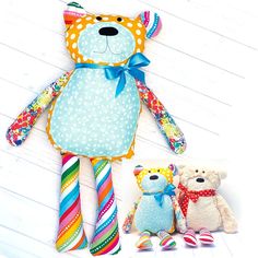 two teddy bears are sitting next to each other on the floor and one is wearing a colorful dress