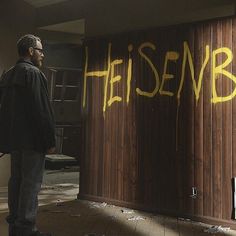 a man standing in front of a wooden door with the word helsenb painted on it