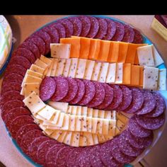 an assortment of cheeses and crackers on a platter