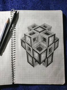 a pencil drawing of a cube on top of a notebook