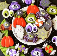 decorated cookies are arranged on a plate for halloween