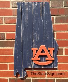 the state sign is made out of wood and has an auburn logo painted on it