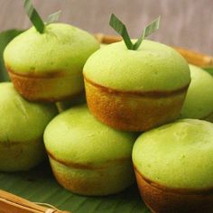 some green cupcakes are sitting in a basket