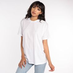 "Vintage 80s t shirt in plain white. Every garment we sell is authentic vintage and one-of-a-kind! You will receive the exact item photographed. Condition: Very good vintage. Has a couple faint spots that should come out with cleaning. Best fits women's: Labelled Extra Large, but runs modern Medium to large Best fits men's: Medium Material: Cotton / polyester blend MEASUREMENTS Taken from seam to seam while the garment is lying flat. Double the armpit, waist, and hips For reference, model is 5'1 T Shirt Basic, Boho Tent, Athletic Crop Top, White Tee Shirt, Cheap Sweaters, Vintage Pullovers, White Tee Shirts, Tent Dress, 70s Dress