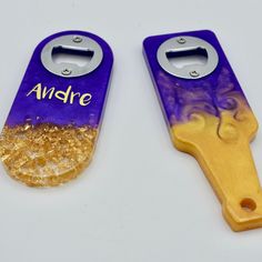 two bottle openers with gold and purple designs on them, one has the word ambre written on it