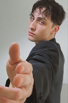 a young man pointing his finger at the camera