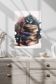 a stack of books sitting on top of a dresser next to a vase with flowers