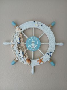 a clock that is on the wall with sea shells and other things around it,