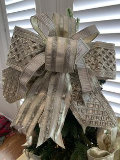 a christmas tree is decorated with bows and ribbons