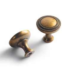 two antique brass knobs on white background