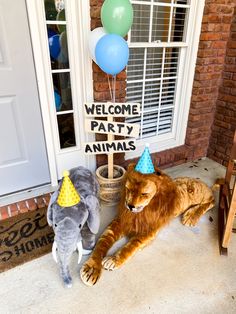 two stuffed animals in front of a welcome party sign