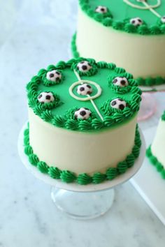 three cakes decorated with green frosting and soccer balls