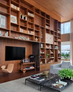 a living room filled with furniture and a flat screen tv on top of a wooden shelf