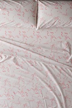 an unmade bed with pink and white sheets