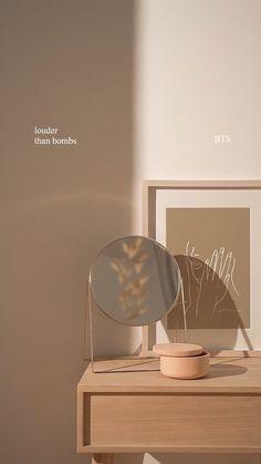 a wooden table with a mirror on it next to a plant in a vase and a framed photograph