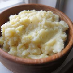 a wooden bowl filled with mashed potatoes