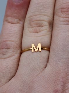 This elegant gold initial ring is perfect for stacking, making it a great gift for any occasion - whether a mother's day surprise or a best friend's birthday present. Crafted from quality stainless steel, this letter ring will look beautiful for years to come. Featuring a letter of your choosing, this ring can be worn alone or stacked making it perfect for gifting to friends or family. The subtle, yet sweet letter ring looks elegant alone or as part of a larger stack. This gold letter ring is th Dainty Gold Stackable Rings With Initials, Simple Gold Initial Ring For Anniversary, Gold Minimalist Personalized Initial Ring, Everyday Gold Monogram Initial Ring, Gold Monogram Initial Ring For Everyday, Personalized Gold Initial Ring Minimalist Style, Minimalist Personalized Gold Initial Ring, Personalized Gold Minimalist Initial Ring, Gold Monogram Initial Ring For Everyday Wear