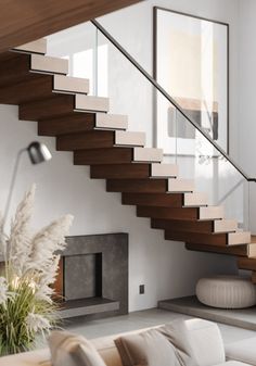 a living room filled with furniture and a fire place next to a stair case on the wall