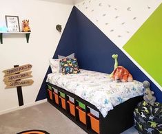 a child's room with a bed and toys on the floor in front of a colorful wall