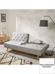 a bed that is in a room with a lamp on the side and a rug