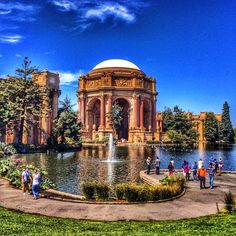 people are standing around in front of a fountain