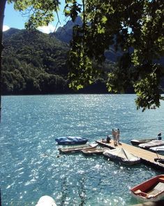 there are many boats that are docked at the water's edge in the lake