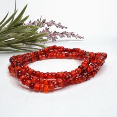 This red glass beaded necklace is made of size 6/0 Czech glass seed beads in a variety of red tones. It can be made as a bracelet, anklet, or necklace - or order it in a stretch option that's long enough for wrapping and you can get a variety of styles from this piece! Note that stretch options will often be finished with a metal bead to secure the knot - the bead will be in the accent metal of your choice if the other beads do not have a sufficient hole size to secure and hide a knot properly. Handmade Red Czech Glass Beaded Bracelets, Red Czech Glass Beaded Bracelets With Colorful Beads, Red Polished Beaded Bracelets For Festival, Red Beaded Bracelet With 108 Beads For Festival, Red Bohemian Beaded Bracelet, Traditional Red Beaded Bracelets For The Beach, Red Czech Glass Beaded Bracelets, Red Polished Beads Necklace For Beach, Red Glass Beaded Bracelets With Round Beads