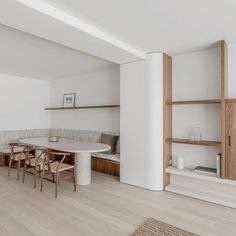 an empty room with white walls and wooden furniture in the center, along with shelves on either side