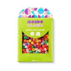 a box of colorful beads sitting on top of a white table next to a green package