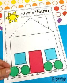 a hand holding up a piece of paper to make a shape house