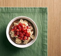 a bowl filled with cereal and toppings on top of a green place mat