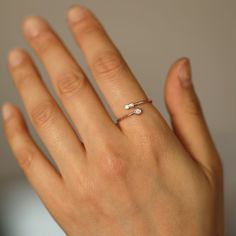 a woman's hand with a diamond ring on it