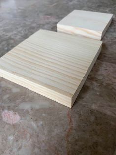 two pieces of wood sitting on top of a marble countertop next to each other