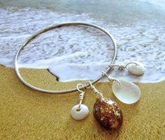 Hawaiian Puka Shell, Sea Glass and Cowrie Bangle - Jewelry by The Beached Mermaid Fabulous Hawaiian shell bangle features a pristine snakehead cowrie, a frosty piece of Hawaiian sea glass, and two pearly white puka shells wrapped in silver plate wire all hanging from a vintage silver tone bangle.  This is the perfect beach accessory worn alone or with a stack of other bangles (see photo #2 for ideas). The cowrie was found in beach wash at one of my favorite secret spots on the island of Oahu.  N Nickel-free Bangle Bracelet For Beach, Nickel-free Bangle Bracelets For Beach, Bangle Stacking, Puka Shell, Stacked Bangles, Beach Accessories, Bangles Jewelry, Beach Jewelry, Bracelet Stack