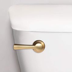 a white toilet with a gold handle on it