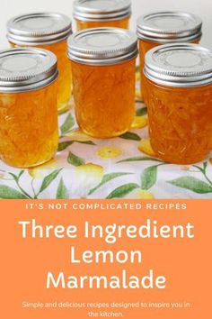 four jars filled with lemon marmalade sitting on top of a floral table cloth