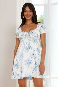 Length from shoulder to hem of size S: 79cm. Chest: 36cm, Waist: 31cm, across front only of size S. Mini dress. Off white with blue print. Semi-lined. Model is a standard XS and is wearing XS. True to size. Non-stretch. Satin. Puff sleeves. Elastic details. Front tie. Slip on. Print placement may vary. Cold hand wash only. Polyester/Cotton. Include the sweetest dress in your wardrobe with the Cottage Blossoms Satin Mini Dress. Featuring elastic puff sleeves and a gorgeous, dainty print. Style wi Light Blue Floral Print Mini Dress With Puff Sleeves, White Floral Print Cottagecore Mini Dress, White Floral Print Mini V-neck Dress, V-neck Summer Mini Dress With Rose Print, Feminine Floral Print V-neck Mini Dress, Long Bodycon Dress, Bridal Shower Dress, Shower Dresses, Jumpsuits And Romper