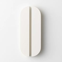 a white wall mounted object with two vertical lines on it's side and one horizontal line at the end