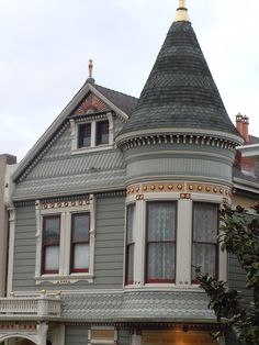 a large gray house with a clock on it's side