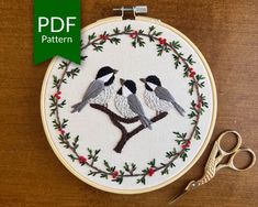 two birds are sitting on a branch with holly wreaths and red berries in the hoop