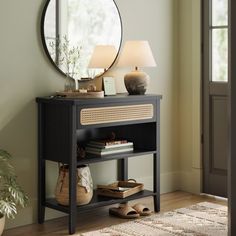 a black table with a mirror and lamp on it next to a rug in front of a door