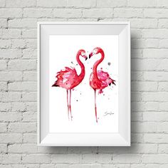 two pink flamingos standing next to each other in front of a white brick wall