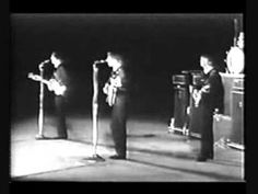 the beatles are performing on stage in black and white