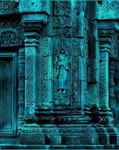 an intricate carving on the side of a building with blue light coming from behind it