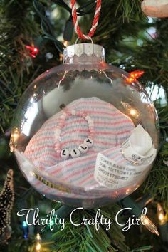 a baby's first christmas ornament hanging from a christmas tree