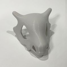 a white ceramic animal head on a white surface